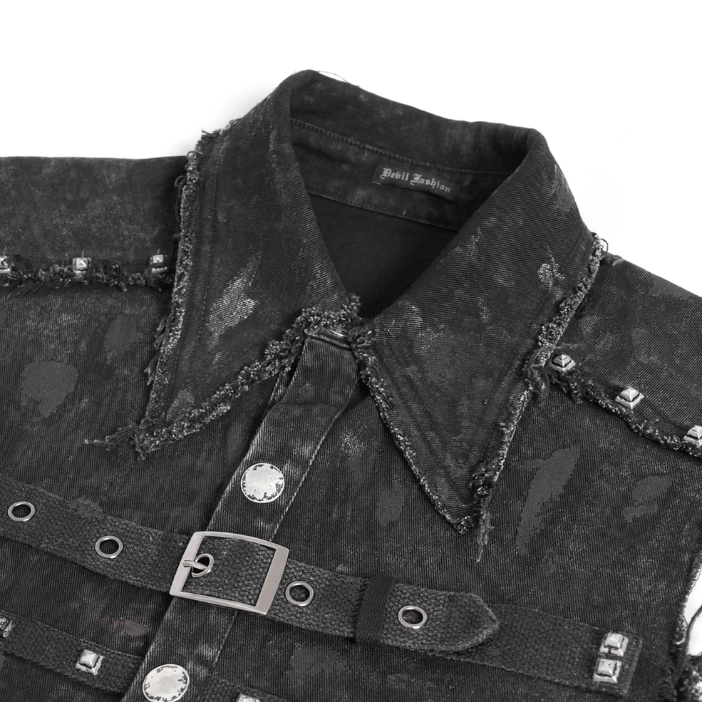 Close-up detail of black denim shirt collar, showing frayed edges, metal snaps, and studded strap embellishments