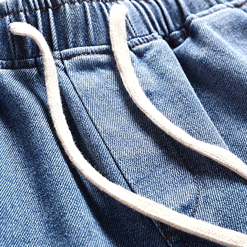 Close-up detail of cotton drawstring waistband on gothic denim shorts showing twill fabric texture