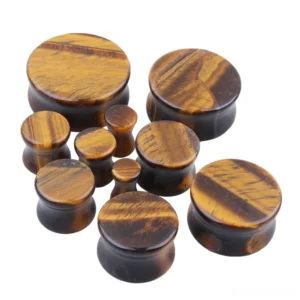 Assorted tiger's eye stone ear plugs and tunnels flat lay showing gauge variety - natural stone body jewelry for gothic aesthetic