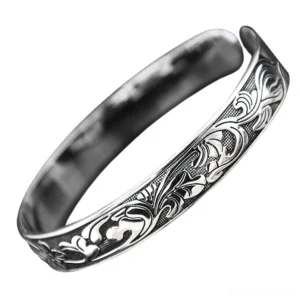 Vintage ornamental silver bangle bracelet with carved vine floral motifs - top down detail view