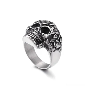 Vintage silver skull ring with floral engravings side profile view, smooth band detail, distressed patina finish