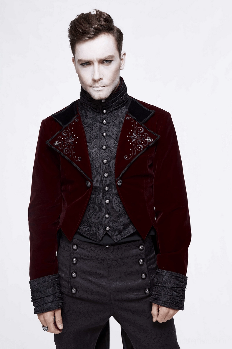 Male model wearing gothic formal outfit in front three-quarter view, displaying dark patterned inner waistcoat and elegant drape