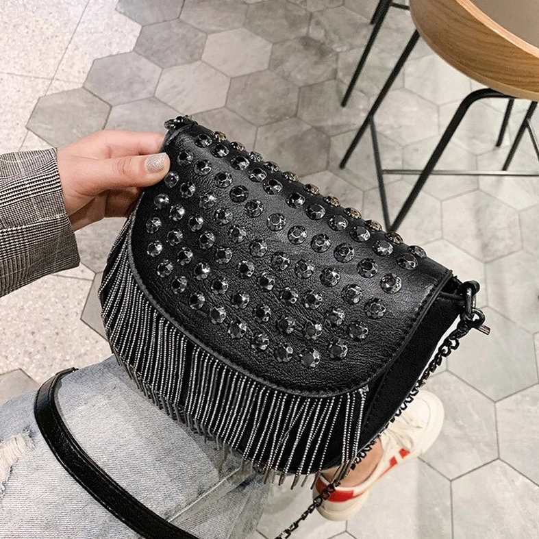 Gothic fringe shoulder bag three-quarter side angle showing rivet-studded flap and chain tassel trim hardware