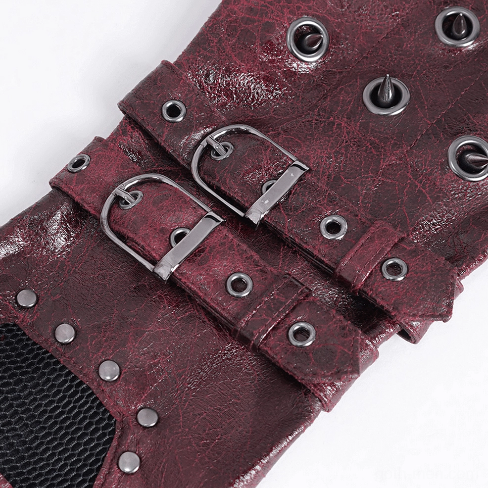 Close-up macro photography of gothic studded gauntlet gloves showing metal spikes, buckles, and textured cracked leather surface detail