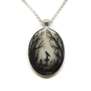 Gothic graveyard hand-painted oval pendant necklace with silver curb chain on white background, showcasing monochromatic raven and cemetery artwork