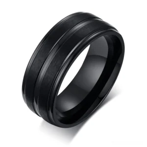 Black matte stainless steel gothic groove ring with geometric pattern, oblique top-down view on white background