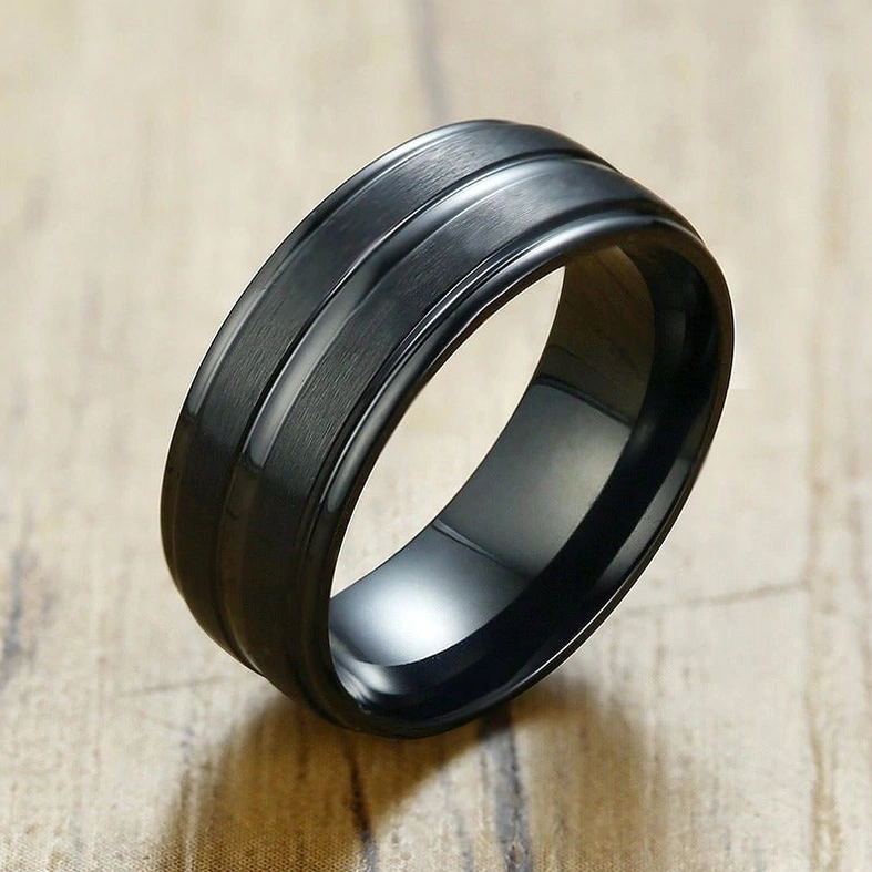 Black matte gothic groove ring side view on wooden surface, brushed industrial finish detail
