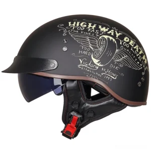 Gothic half-face biker helmet matte black with winged tire graphic and red safety buckle - front left angle view