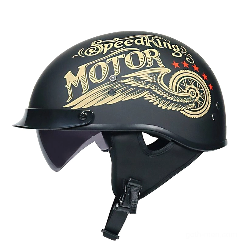 Gothic half-face biker helmet with gold wing accents, matte black finish, front-left studio view with integrated sunglasses