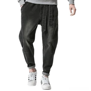 Men's faded black gothic harem denim jeans with drawstring belt, front lower-body view showing rolled cuffs