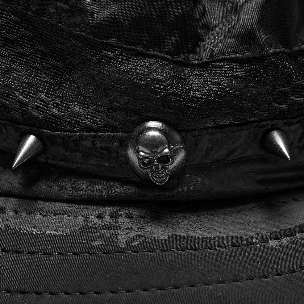 Close-up top view of black gothic hat band featuring skull stud, spike studs, and distressed woven texture