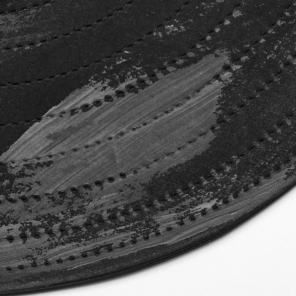 Close-up overhead view of black gothic hat brim showing faded distressed fabric texture and stitched edge details