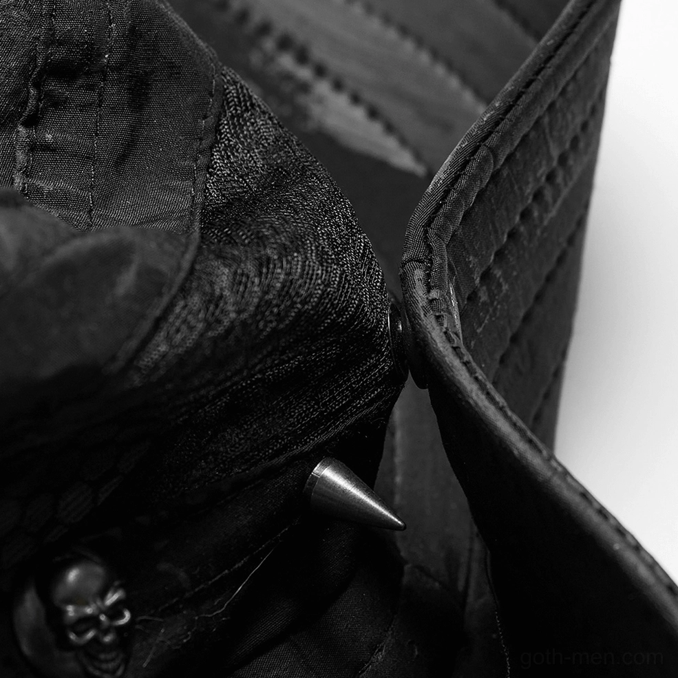 Close-up detail of black gothic hat showing skull metal charm, spike decorations, and stitched seams
