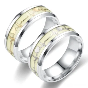 Polished stainless steel ECG heartbeat couple rings with luminous cream inlay, overhead oblique view