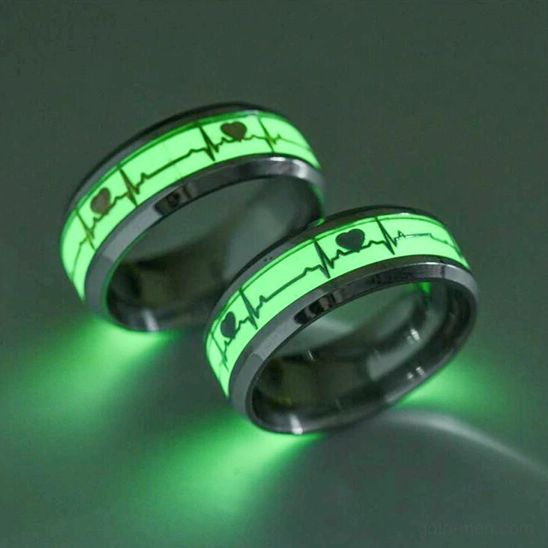 Glowing green ECG heartbeat couple rings on dark background, bright phosphorescent inlay detail
