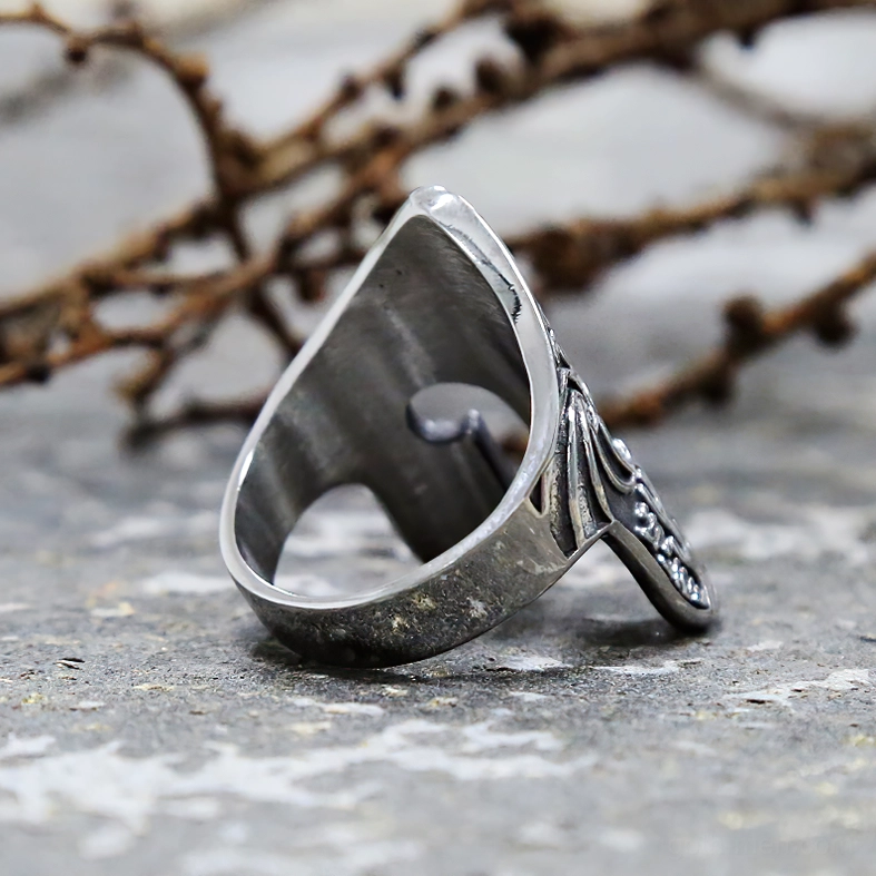 Dark aged silver gothic helmet ring back side view with carved band patterns on stone surface