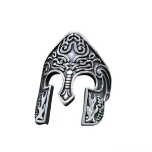 Aged silver gothic warrior helmet ring with dark patina and detailed mythical engravings, tilted angle