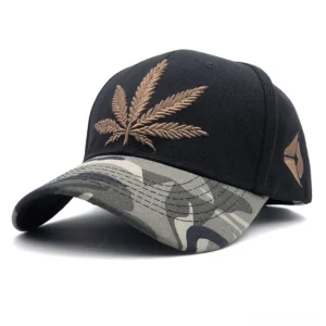 Black baseball cap with brown hemp leaf embroidery and grey camo brim, front three-quarter angle displaying goth-inspired design details