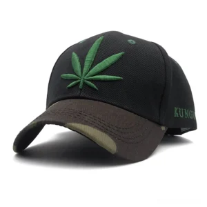 Green hemp leaf embroidery gothic baseball cap with camouflage brim, front three-quarter view showcasing alternative streetwear style