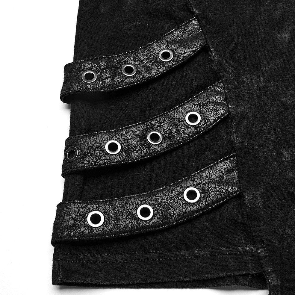 Close-up detail of black gothic hooded vest side hem showing cracked faux leather straps with multiple metal eyelets