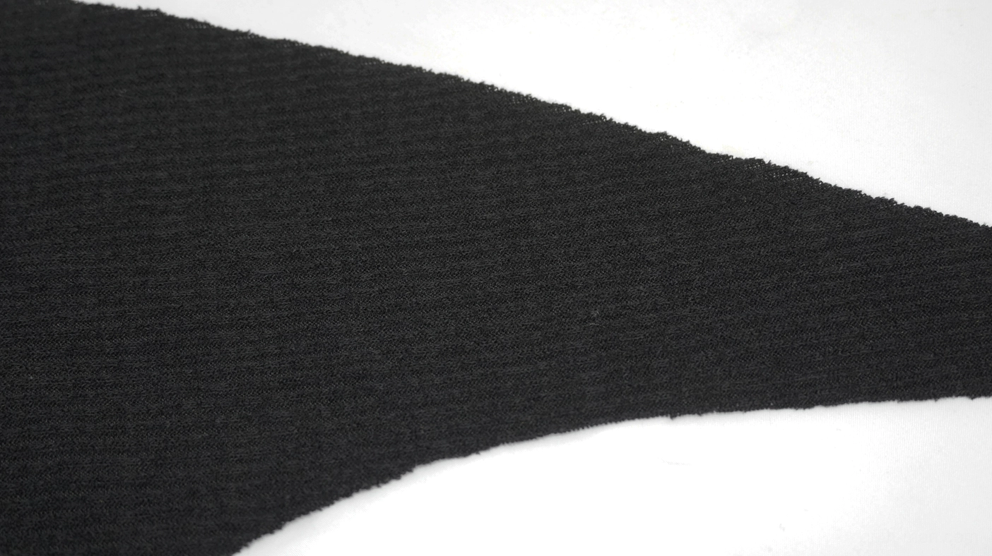Asymmetric fabric panel detail of black gothic hoodie, ribbed knit with irregular cut edge