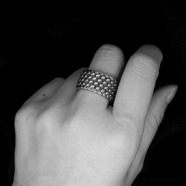 Black and white artistic shot of gothic stainless steel interwoven ring on hand