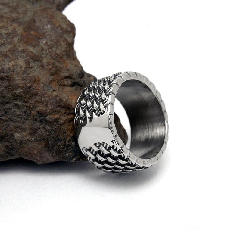 Gothic stainless steel ring detail shot showing braided exterior texture against stone backdrop