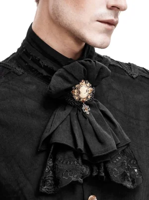 Close-up detail of layered black lace jabot showing intricate embroidered hem and gold-toned brooch fastener on male model