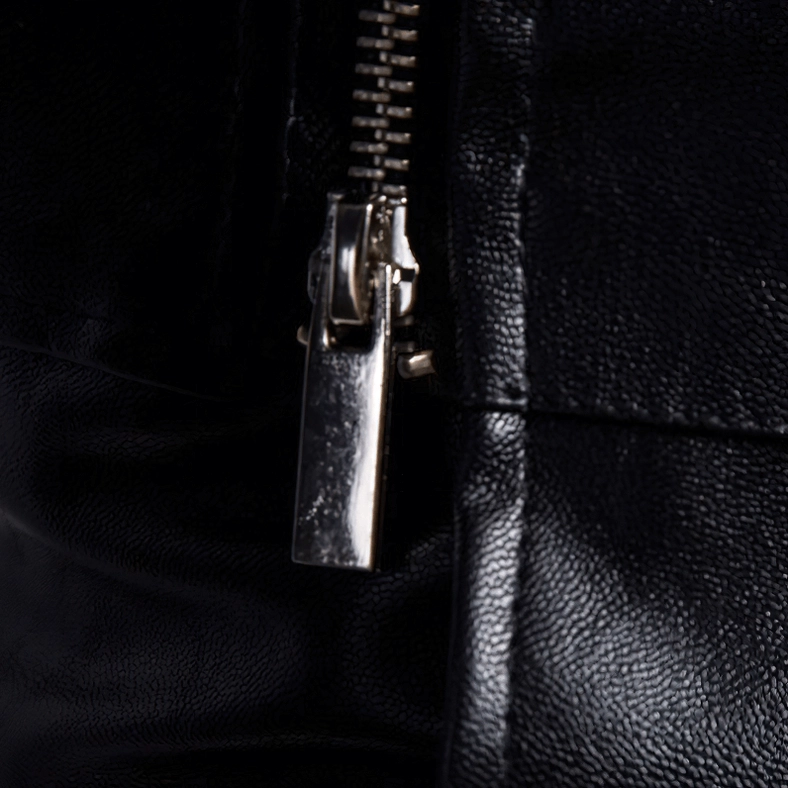 Macro photograph of gothic jacket polished silver metal zipper slider mechanism