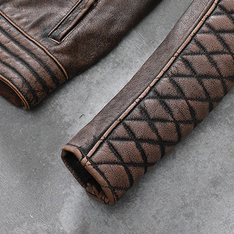 Sleeve close-up of brown leather biker jacket showing diamond quilted pattern, ribbed cuff and grain texture