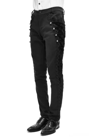 Men's gothic black jacquard slim-fit pants with decorative side lace panels and metal accents, side front view on model