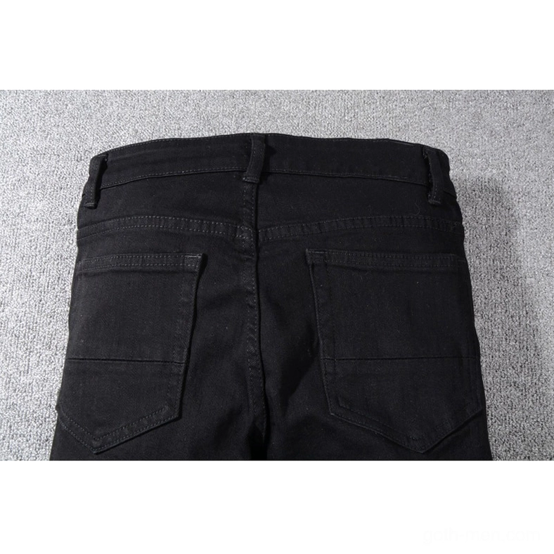 Back waist detail of black distressed jeans showing dual reinforced patch pockets with metal rivets