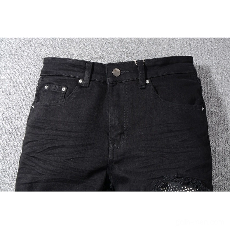 Close-up detail of gothic jeans waist and front pocket with metal button and rhinestone accent