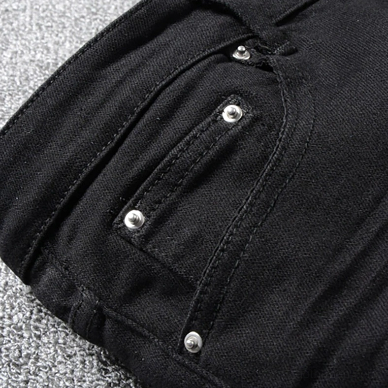 Close-up macro shot of metal rivets on gothic distressed jeans front pocket corner