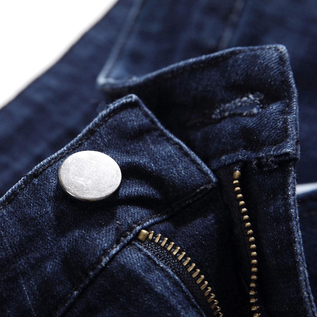 Close-up of metal button and zipper fly closure on navy gothic denim jeans