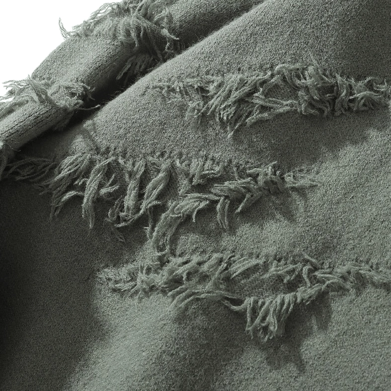 Close-up detail of distressed ripped slash patterns on sage green gothic jumper