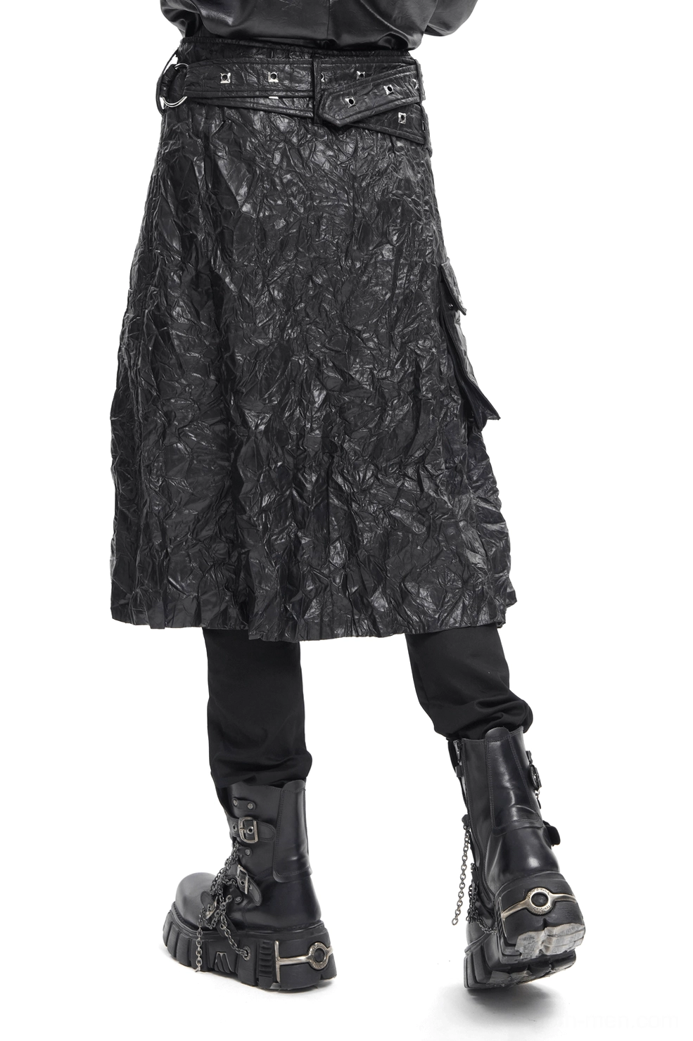 Black crinkled leather gothic kilt side rear view displaying adjustable waist belt and midi-length draped silhouette on male model wearing chain platform boots