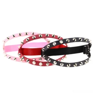 Three pairs of gothic spiked knee garters arranged flat, featuring cone studs and adjustable buckles in various color options