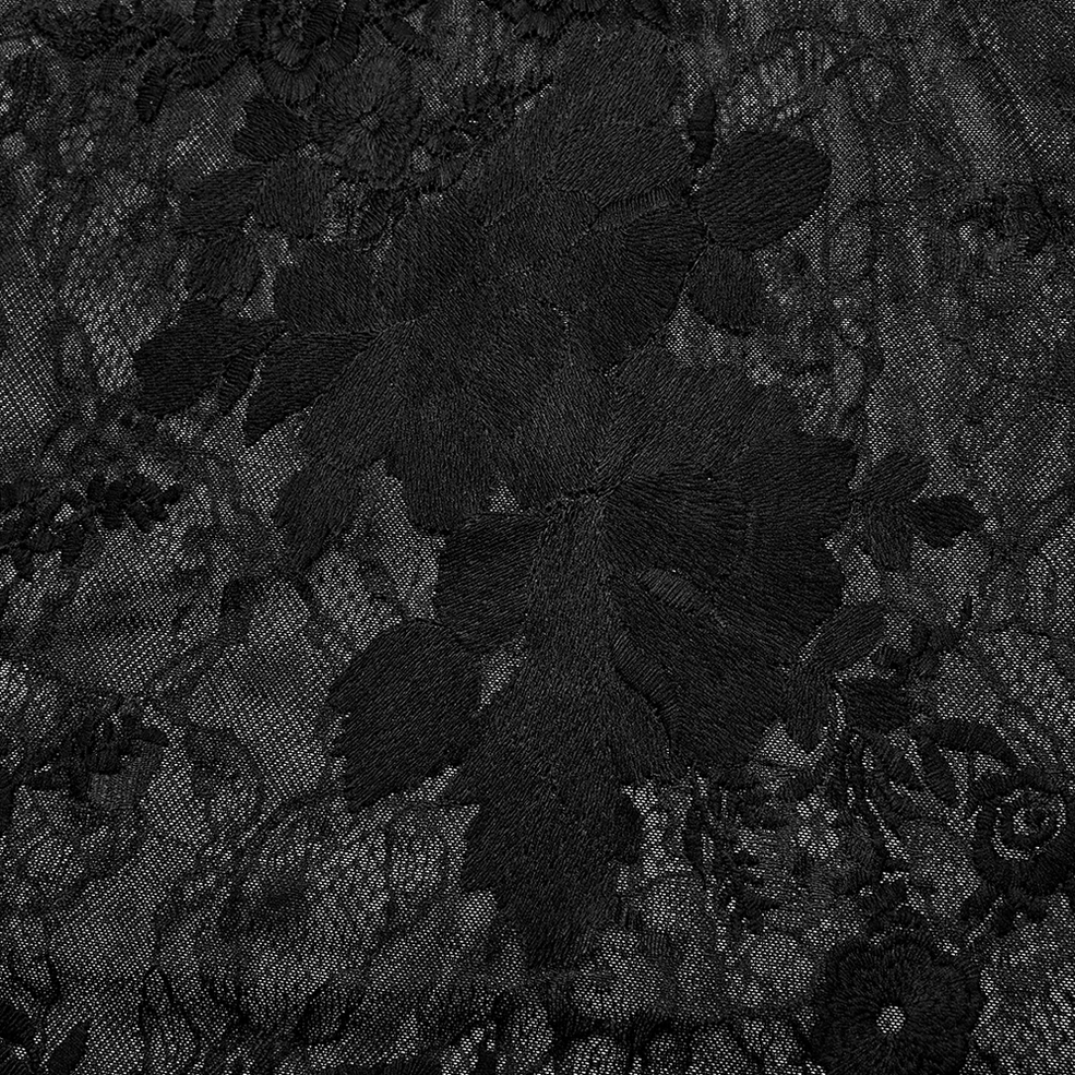 Extreme close-up macro view of black floral embroidered lace fabric showing intricate pattern and sheer mesh