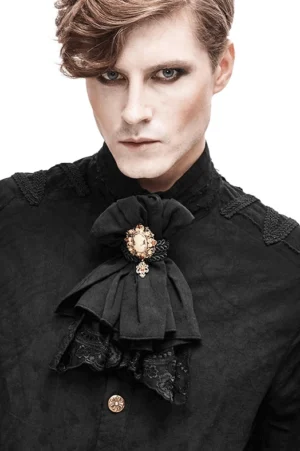Gothic black lace jabot necktie with vintage cameo brooch worn by male model, front view showing cascading ruffled lace and floral embroidery details