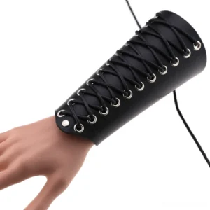 Gothic lace-up leather wrist cuff bracelet in black with metal eyelets and rope lacing, worn on mannequin hand in studio setting