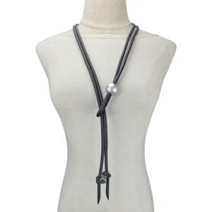 Women's black rubber gothic lariat necklace with pearl and screw accents displayed on dress form mannequin, front view