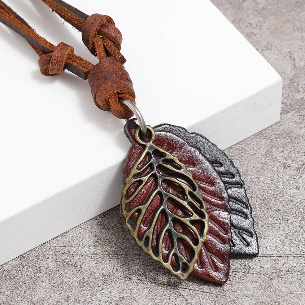 Two retro gothic leaf pendant necklaces in mixed colors showing punk vintage style with matching leather straps - flat lay