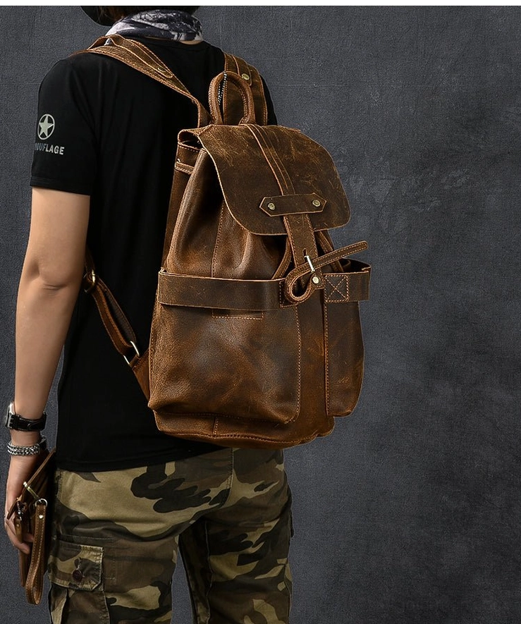 Rear side angle of compact retro leather gothic travel backpack on male model dark aesthetic styling