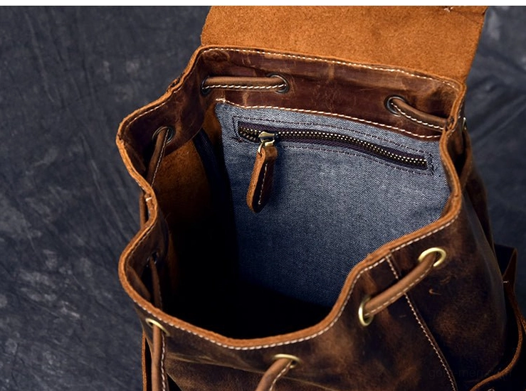 External flap pocket with decorative belts and metal studs on dark gothic leather travel backpack