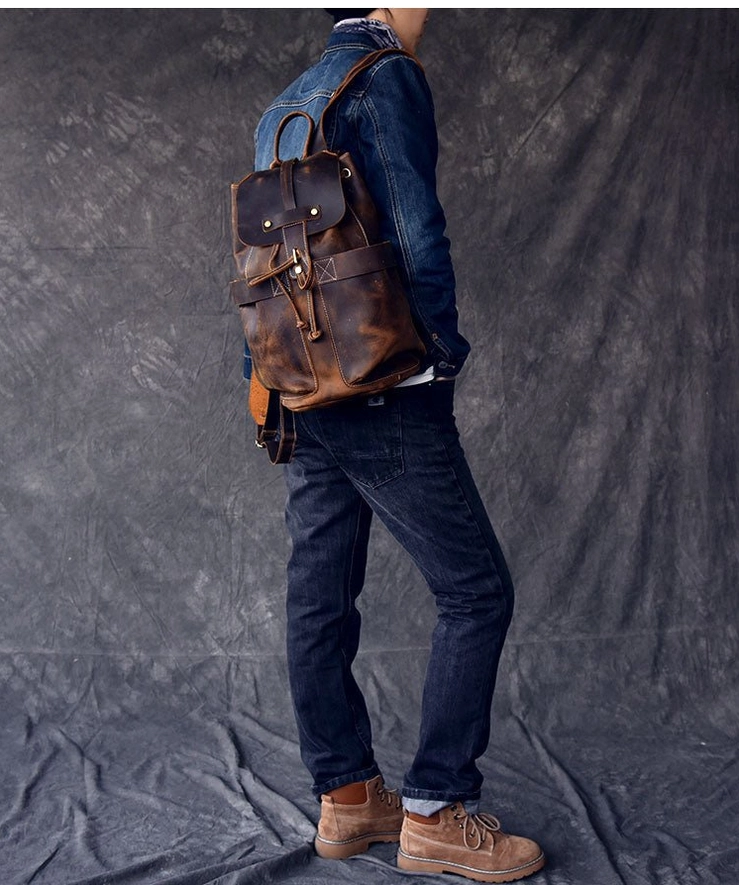 Side profile of dark vintage leather gothic travel backpack on male model with casual workwear styling