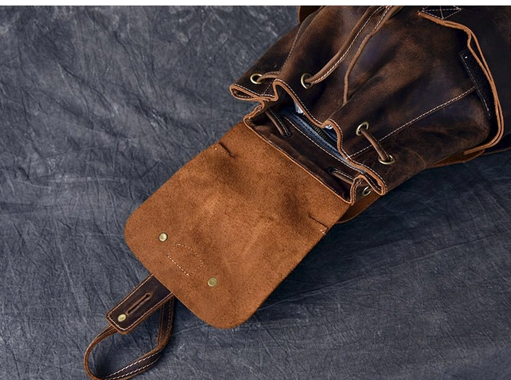 Steampunk-inspired brass fasteners and drawstring closure detail on genuine leather gothic travel backpack