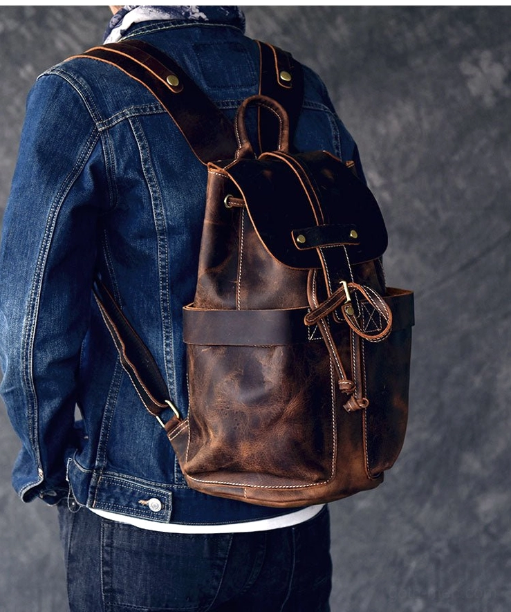 Male model wearing brown distressed leather gothic backpack with denim jacket casual dark aesthetic styling