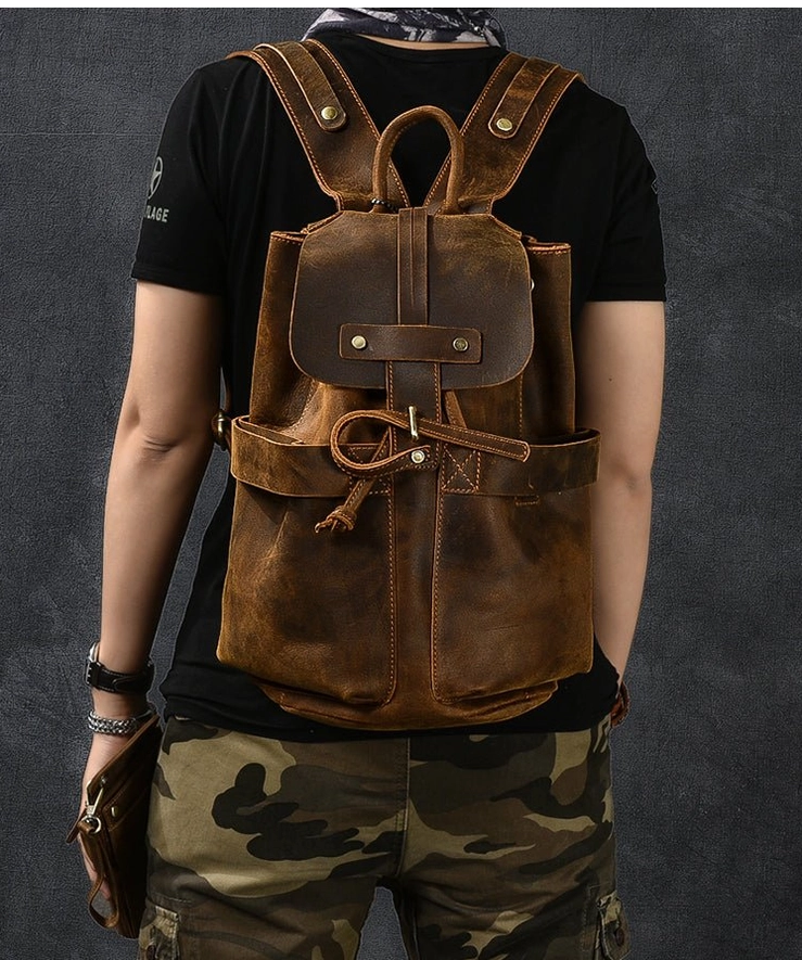Rear view of distressed leather gothic backpack on male model wearing black tee and tactical pants