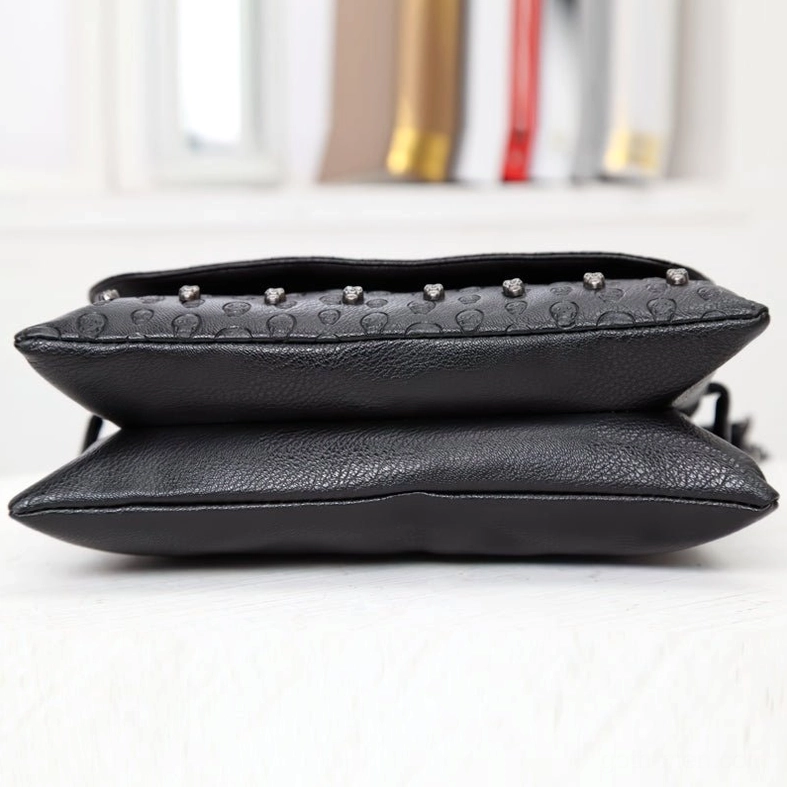 Top-down flat lay view of black embossed skull leather gothic bag showing rivet trim and compact design